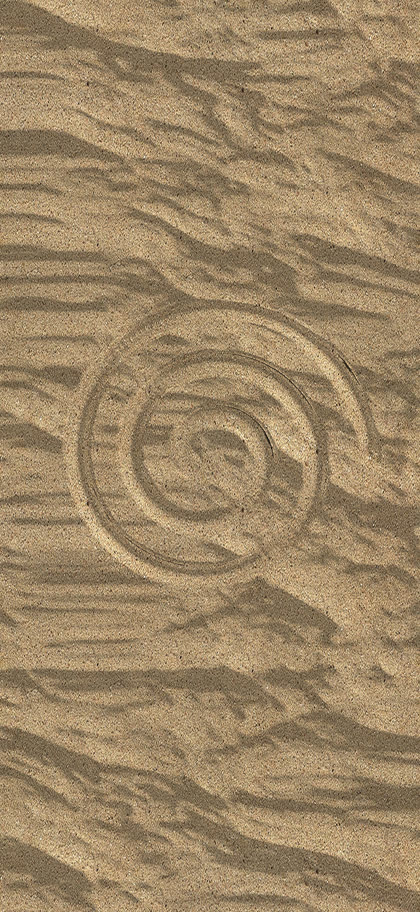 a spiral carved in sunlit sand